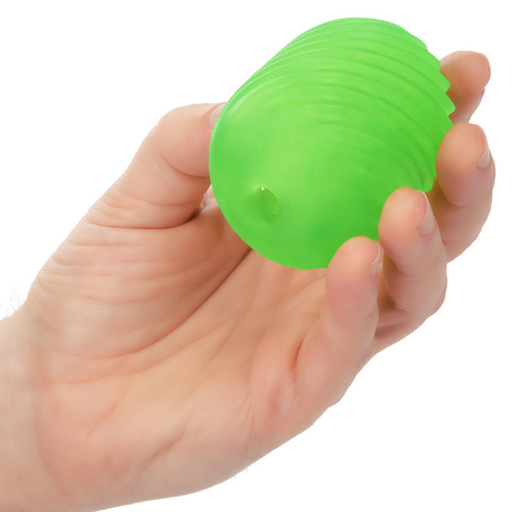 A green textured stroker held in a hand.