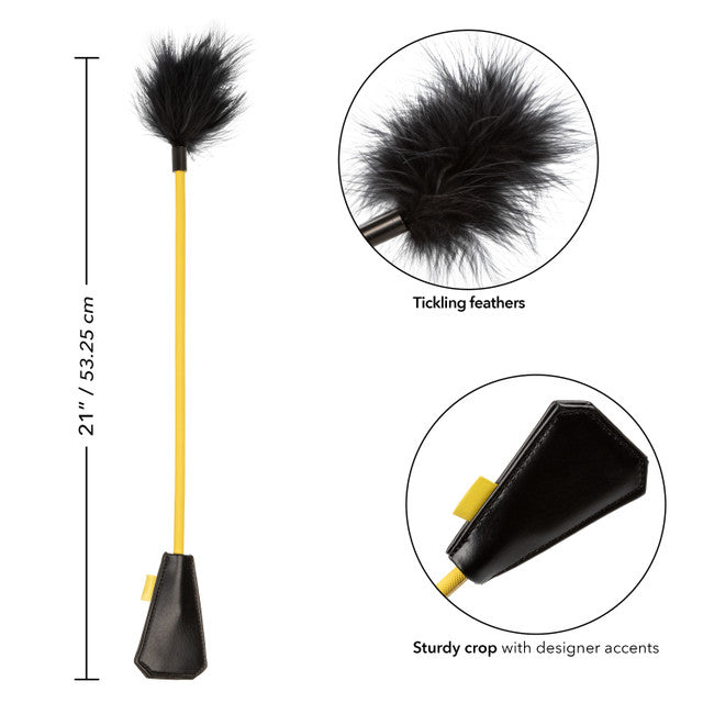 A yellow crop with black feathers and a faux leather handle.