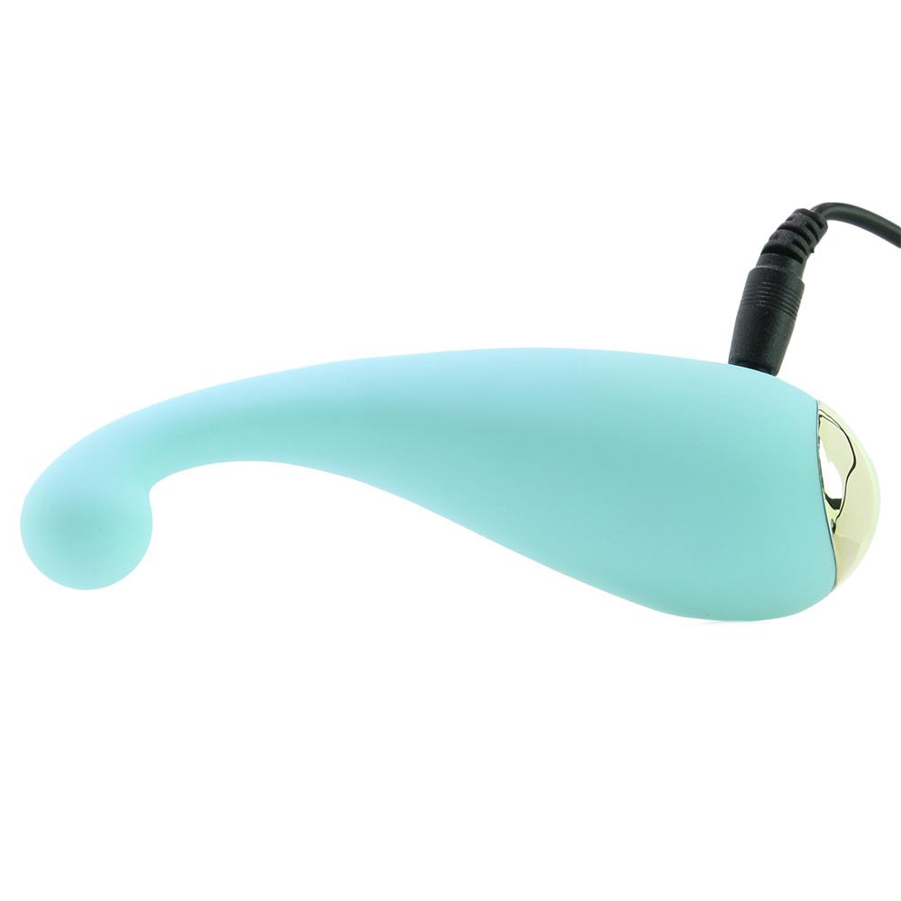 A teal finger massager with a gold tip and charging cable.
