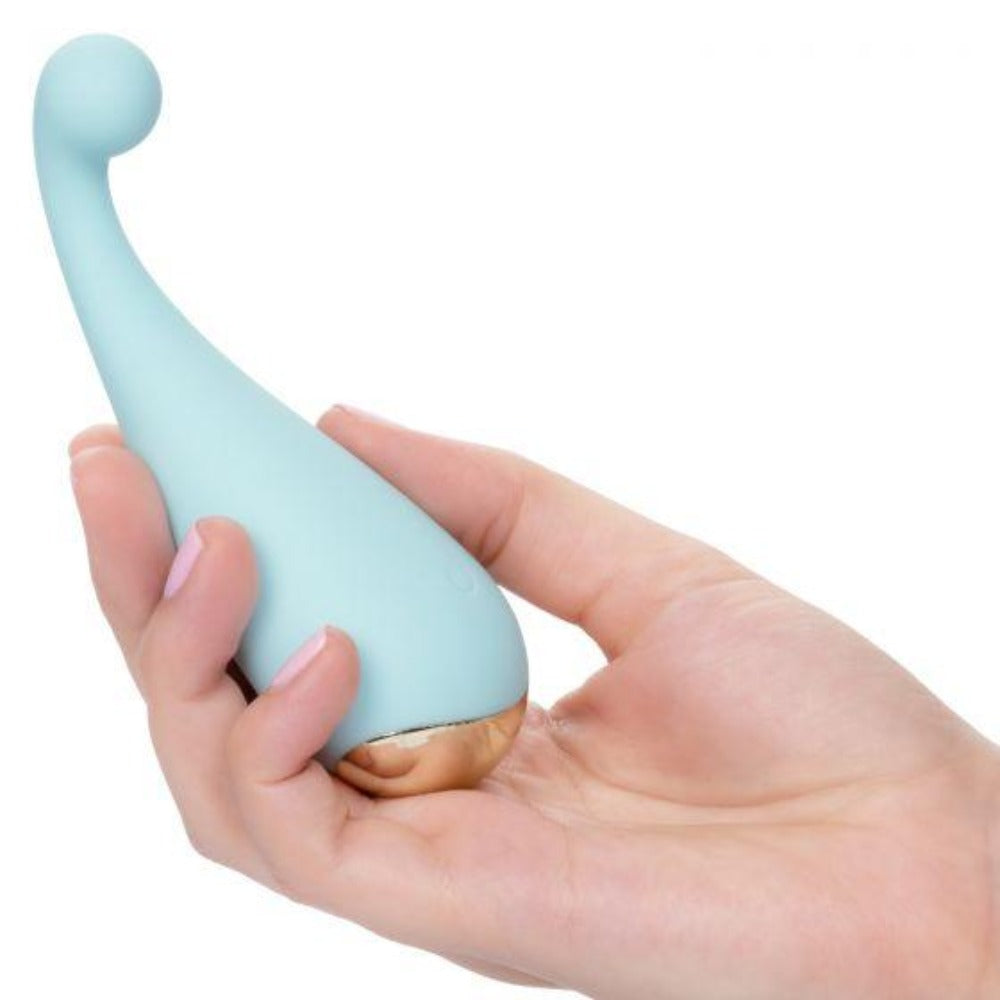 A light blue finger massager with a gold base held in a hand.