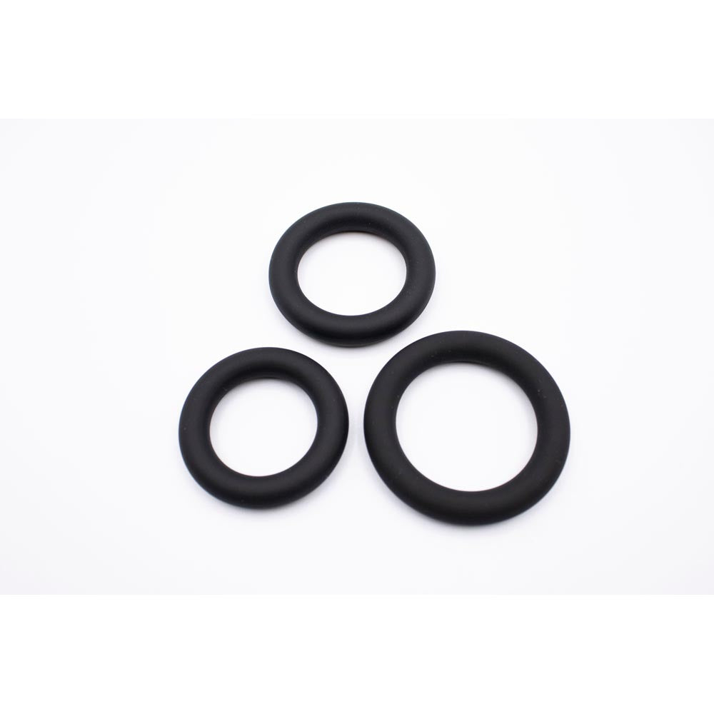 Three black silicone rings of varying sizes on a white background.