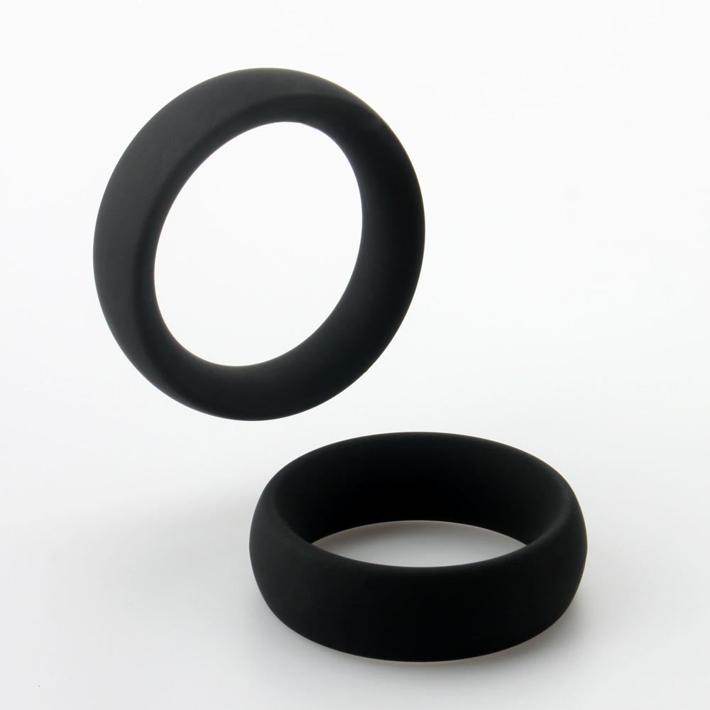 Two black silicone rings, one floating above the other.