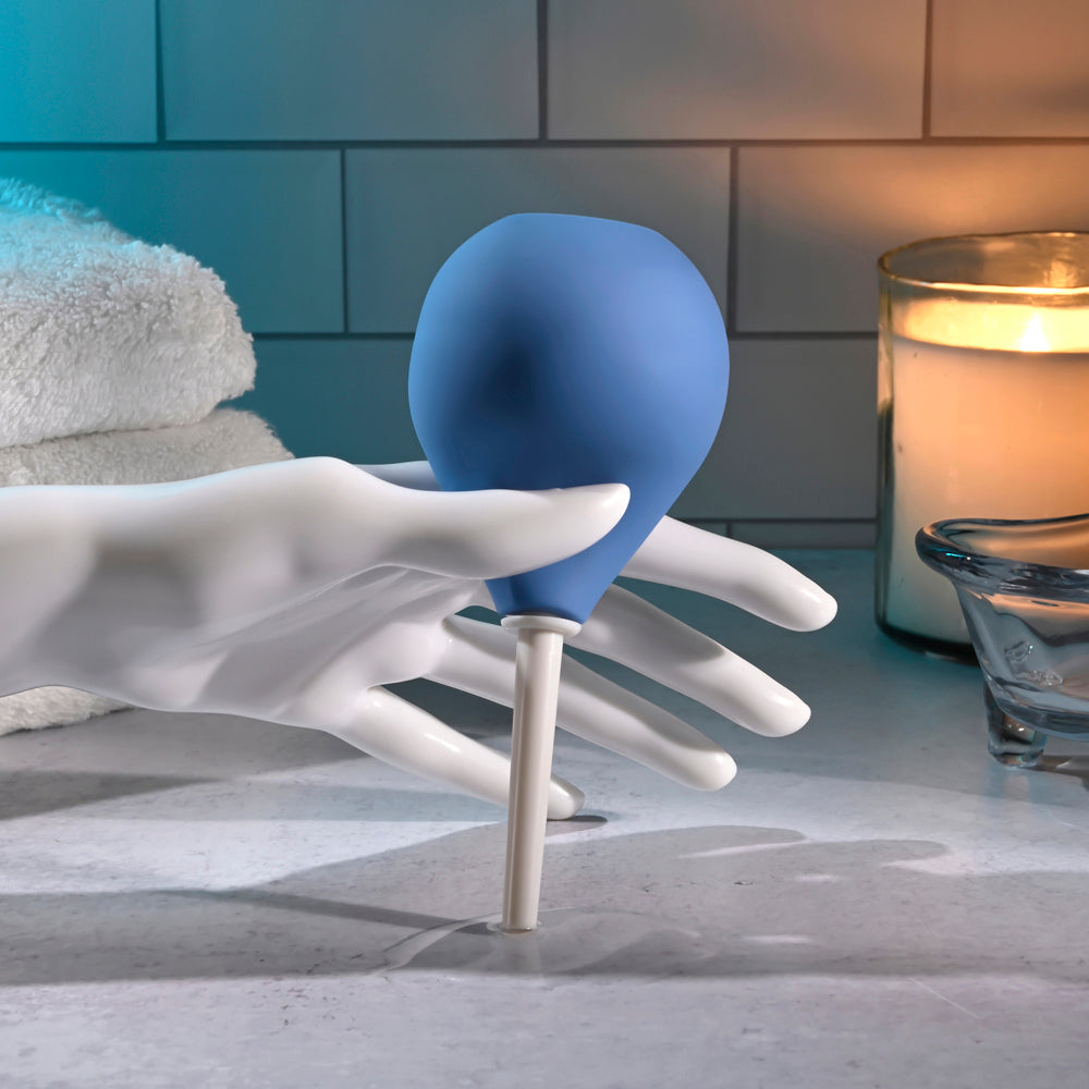 Blue silicone anal cleansing douche held by a white mannequin hand.