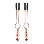 Rose gold nipple clamps with adjustable rubber tips and hanging beads.