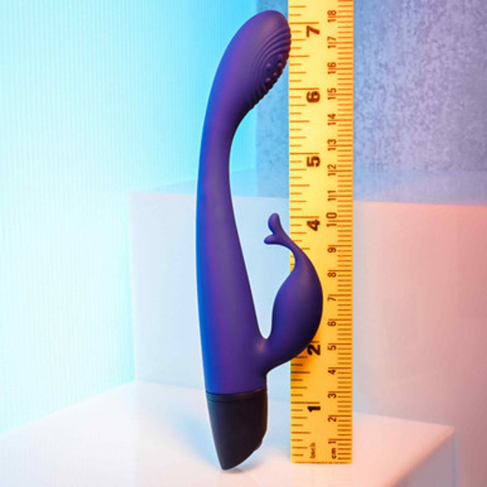 A plum-colored rechargeable G-spot rabbit vibrator is shown next to a ruler.