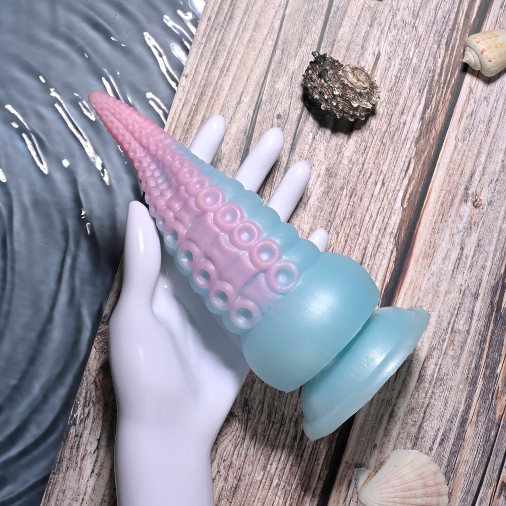 A blue and pink silicone tentacle toy with suckers on a white hand.