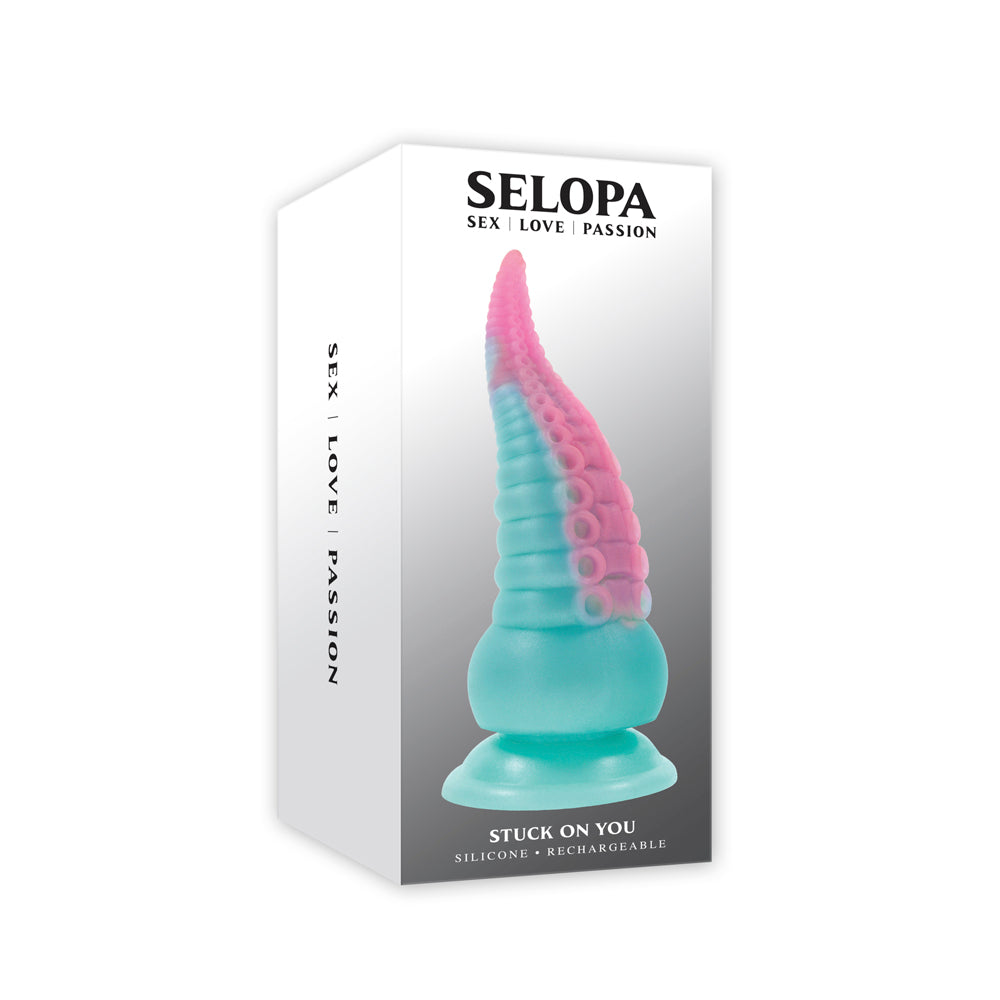 A teal and pink silicone tentacle toy with suckers on a white box.