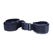 Black adjustable ankle restraints with a buckle.