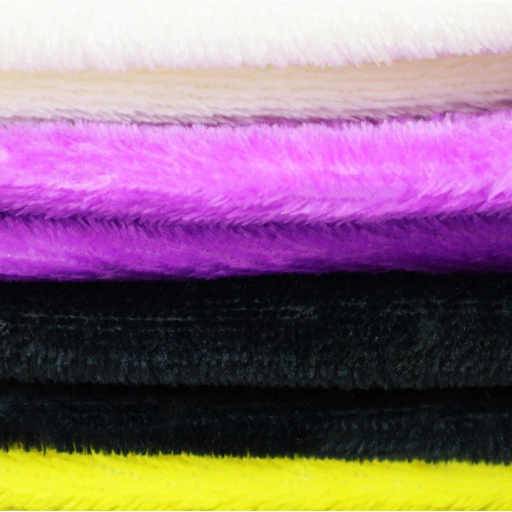 A stack of plush fleece fabric in white, beige, purple, black, and yellow.