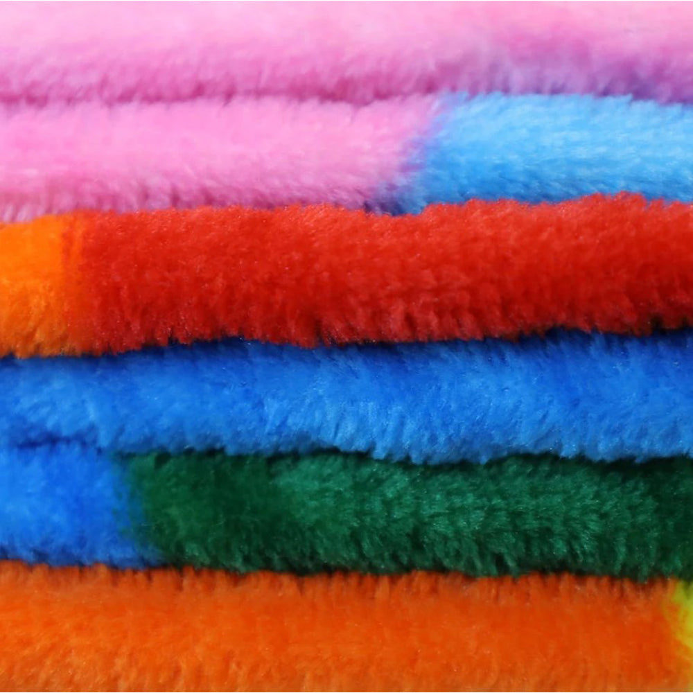 A stack of colorful, fluffy polar fleece blankets in rainbow hues.