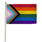 Progress Pride flag on a wooden stick.