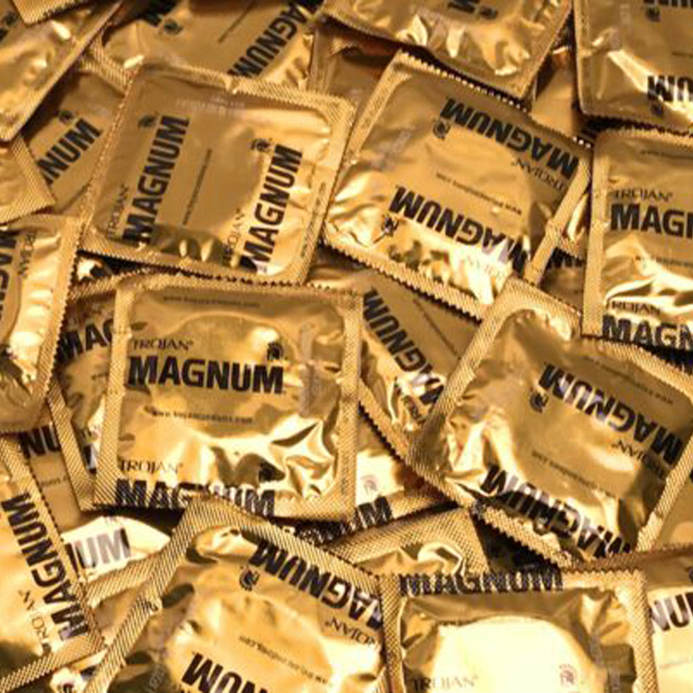 Pile of gold-wrapped Trojan Magnum condoms.
