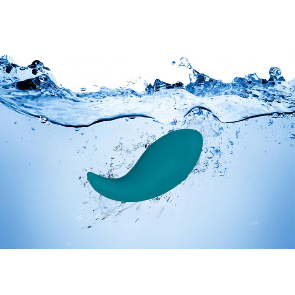 Teal waterproof silicone vibrator submerged in water.