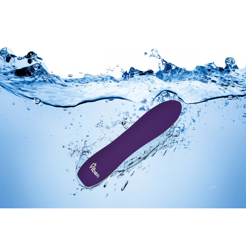 Violet silicone bullet vibrator submerged in water.