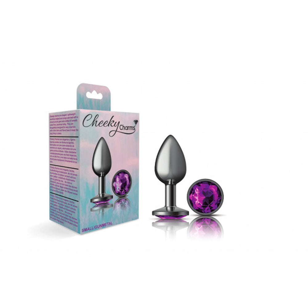Small metal anal plug with a purple gemstone on a stand and next to it.