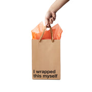 A hand holds a kraft paper gift bag with orange tissue paper and the text "I wrapped this myself".