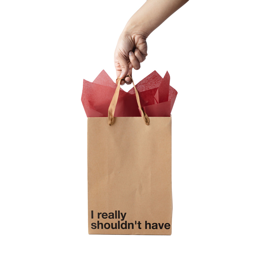 A brown kraft gift bag with red tissue paper and the text "I really shouldn't have".