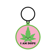 A round keychain with a smiling cannabis leaf and "I AM DOPE" text.