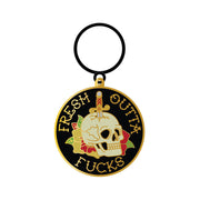 Black and gold keychain with a skull, dagger, roses, and "Fresh Outta Fucks" text.
