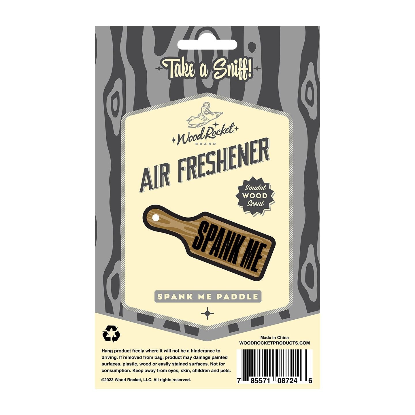 A sandalwood scented air freshener shaped like a paddle with "Spank Me" written on it.
