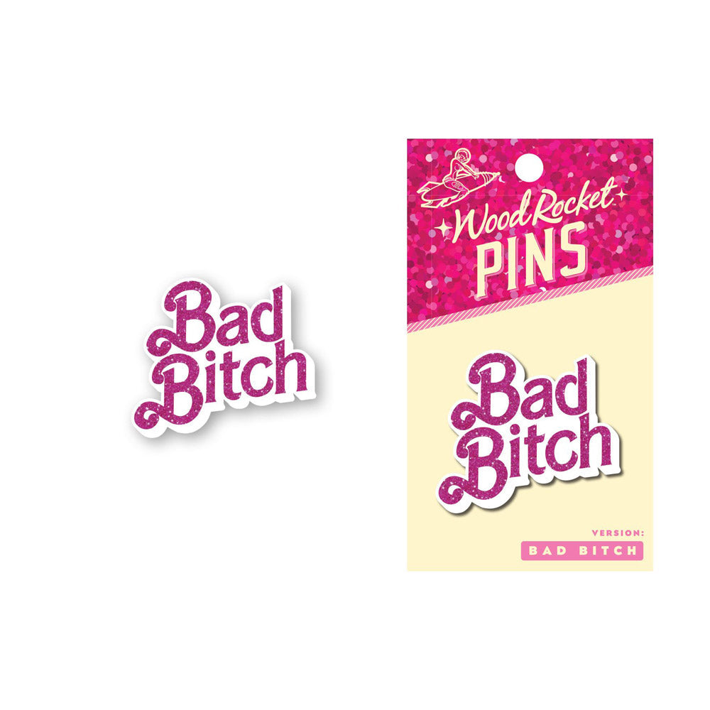 Pink glitter "Bad Bitch" enamel pin on packaging.