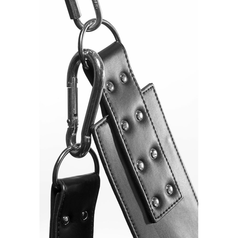 Black leather bondage sling with metal carabiners and stirrups.