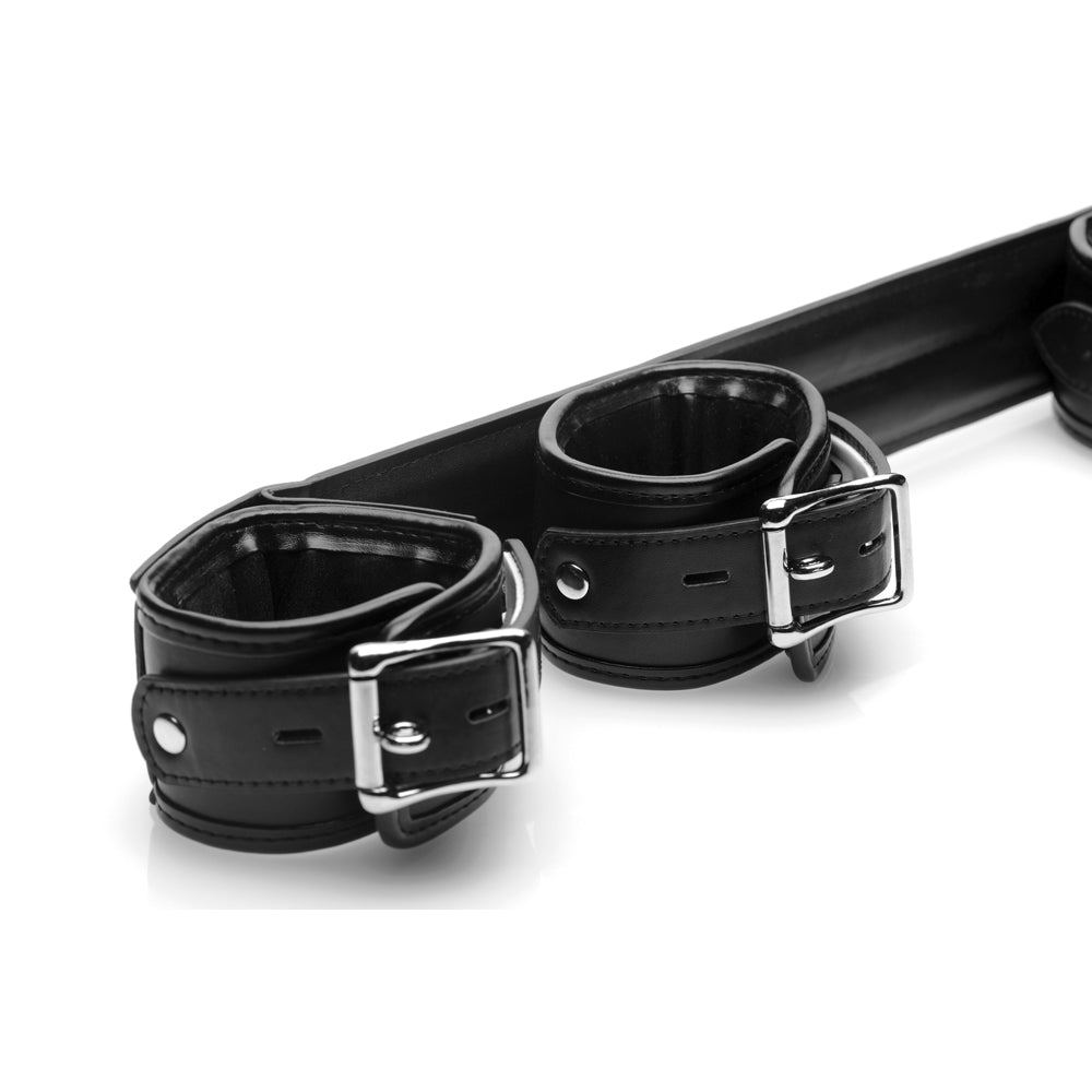 Rigid spreader bar with two black padded leather cuffs and silver buckles.
