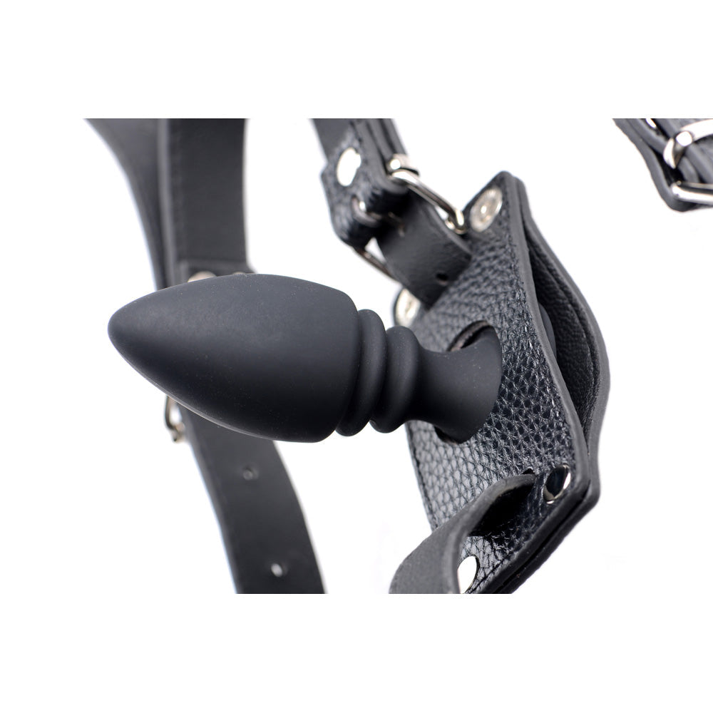 Black leather harness with a black silicone anal plug.