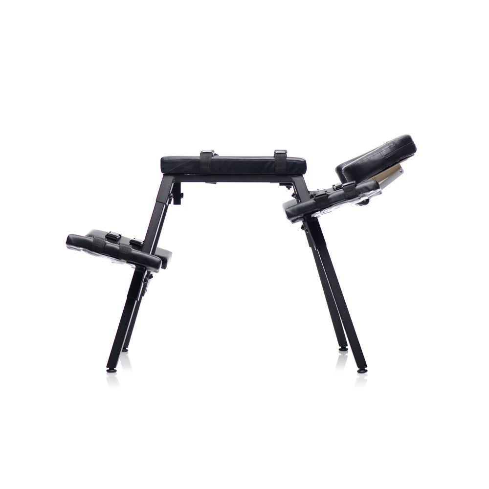 Black steel sex bench with padded rests and restraints.