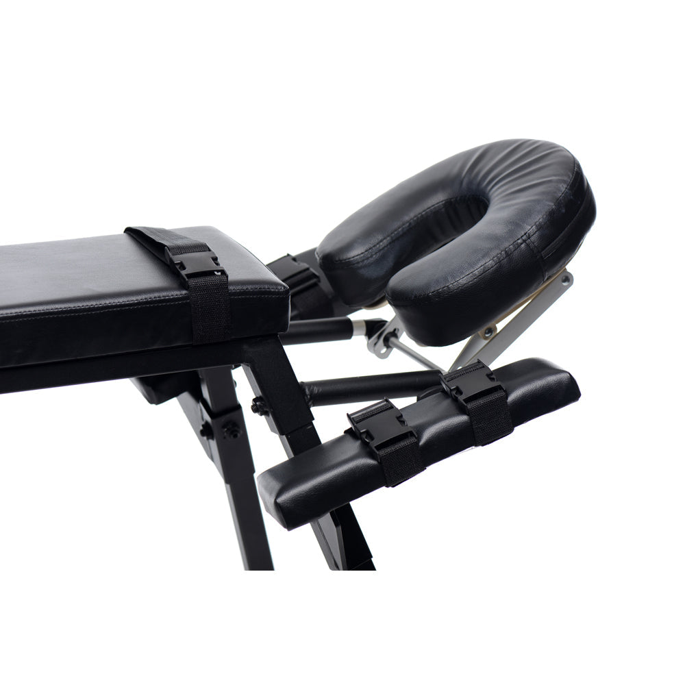 Black sex bench with headrest and adjustable restraints.
