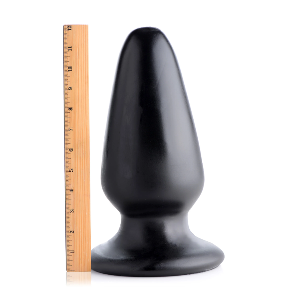 Black PVC Gigantor XXXL tapered anal plug with a ruler for scale.