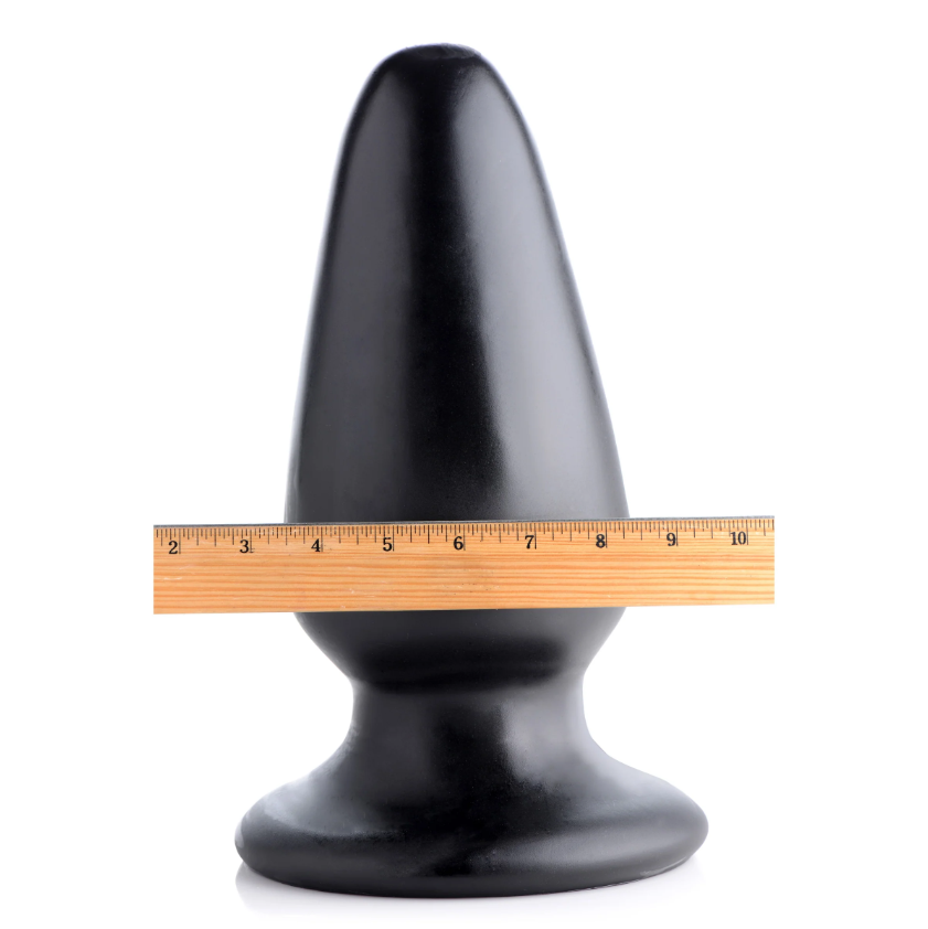 Black PVC Gigantor XXXL tapered anal plug with ruler for scale.