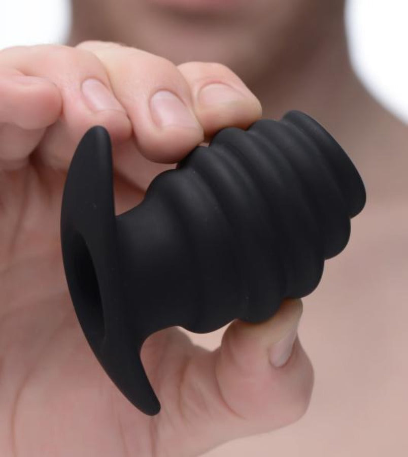 Black silicone ribbed hollow anal tunnel plug with a flared base.