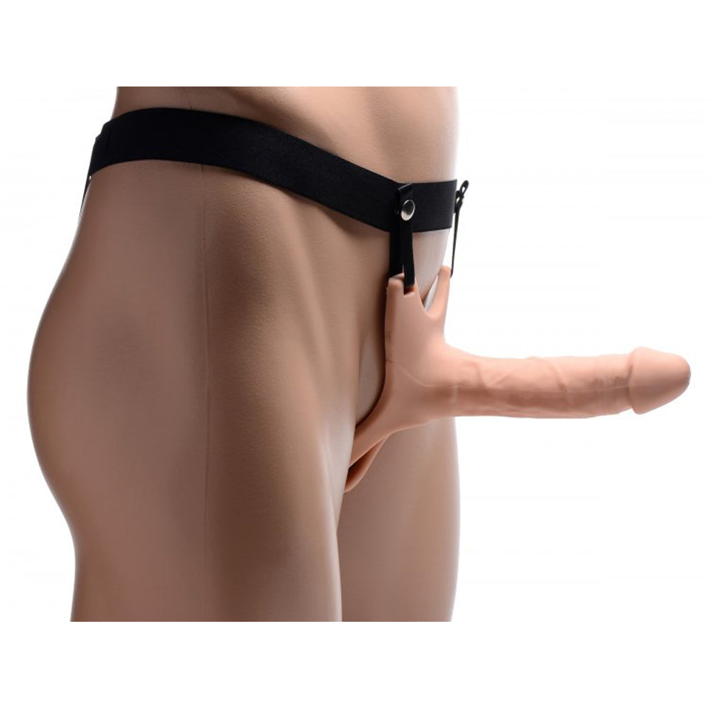 Flesh-colored hollow silicone dildo strap-on with realistic veins and secure harness.