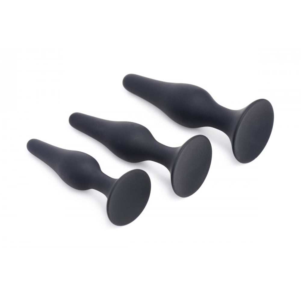 Three black silicone anal trainers of graduated sizes on a white background.