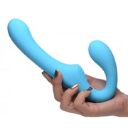 A blue vibrating strap-on held in a hand.