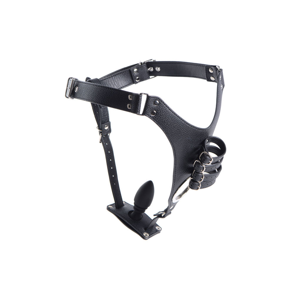 Black leather chastity harness with adjustable straps and a silicone anal plug.