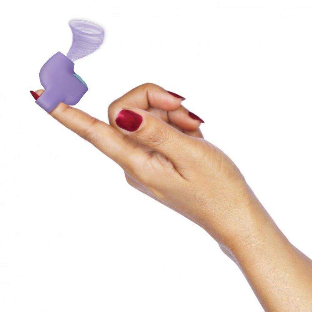 Purple mini silicone clitoral suction stimulator on a finger.