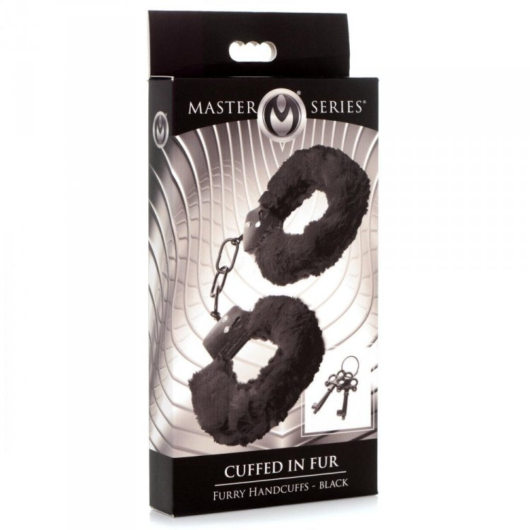 Black furry handcuffs with metal locks and two keys on a box.