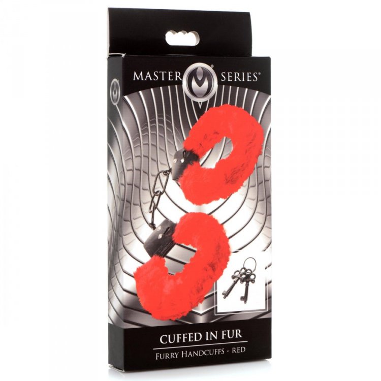 Red faux fur handcuffs with keys on a black box.