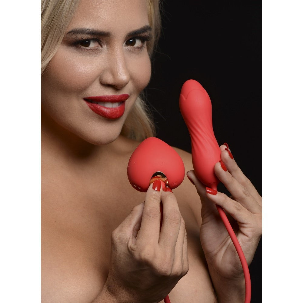 A woman holds a red heart-shaped clitoral stimulator and a red vibrating egg.