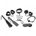 Black vegan leather bondage set with cuffs, collar, leash, ball gag, flogger, paddle, and blindfold.