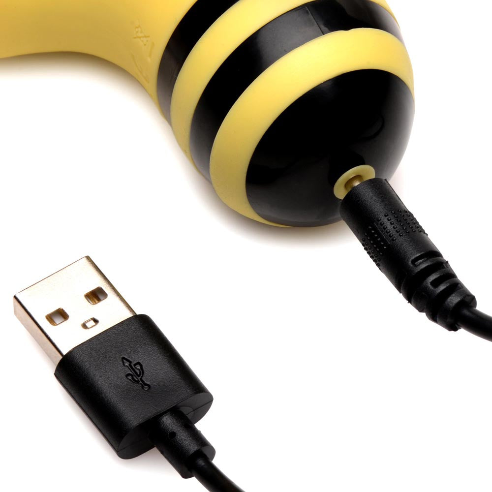 A yellow and black striped bee-shaped vibrator with a USB charging cable.
