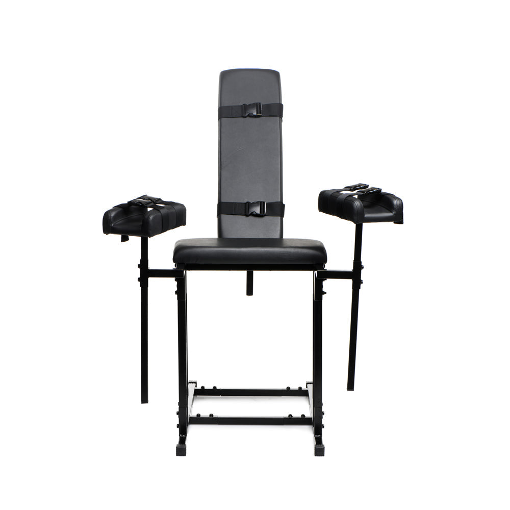 Black adjustable bondage chair with padded seat, backrest, and armrests with straps.