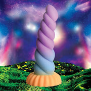 A twisted unicorn horn dildo in purple and blue with an orange suction cup base.