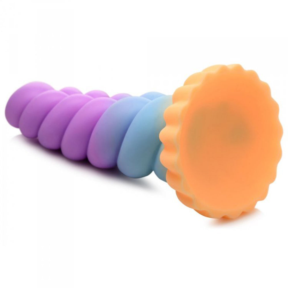 A rainbow-colored silicone dildo with a twisted horn design and a scalloped suction cup base.