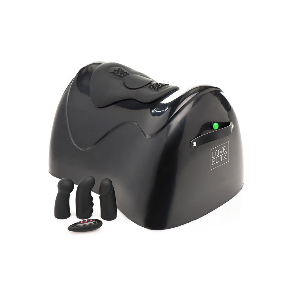 Black sex machine with three attachments and a remote.