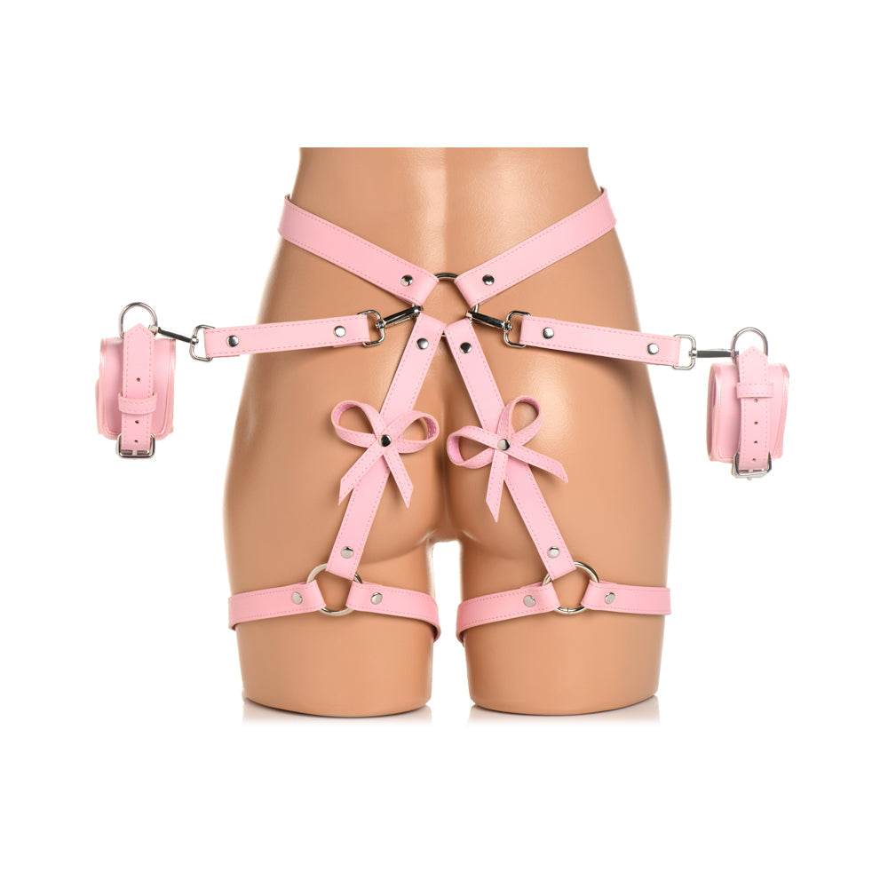 Pink vegan leather bondage harness with bows and wrist cuffs.