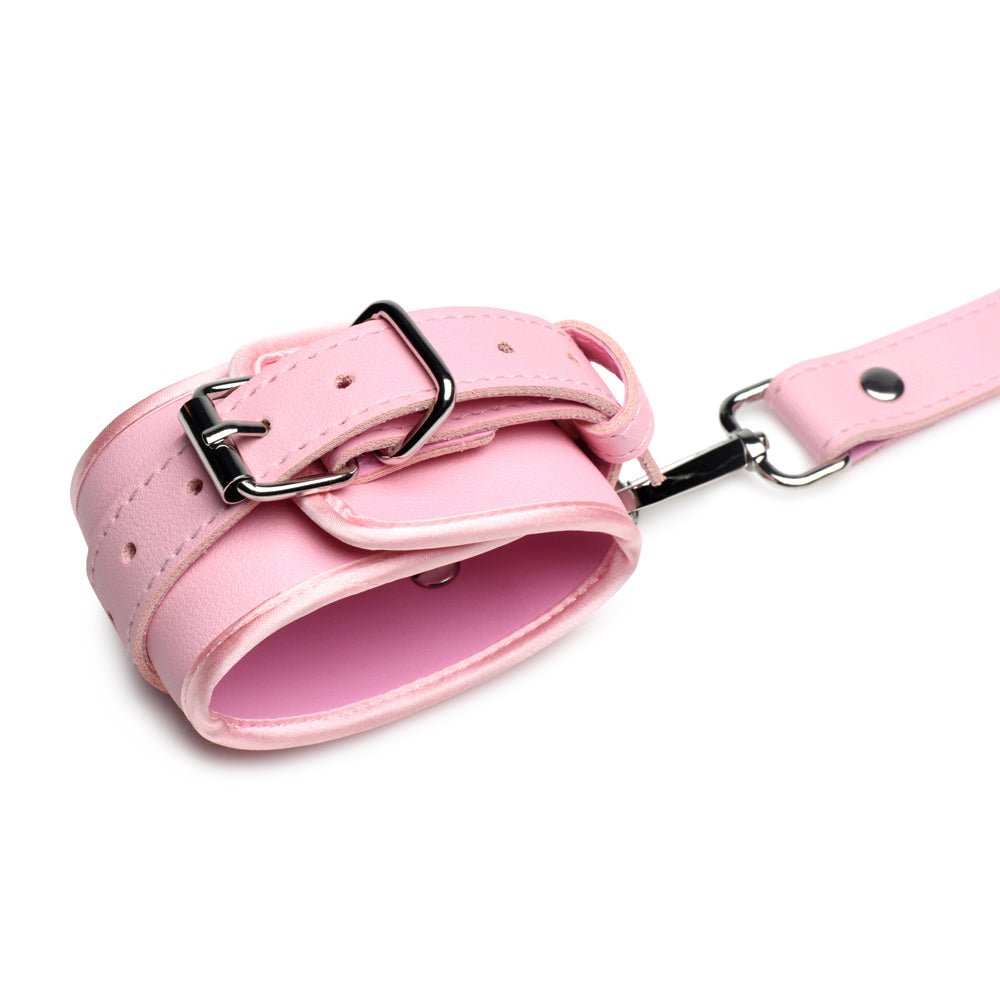 Pink vegan leather wrist cuff with silver buckle and leash attachment.