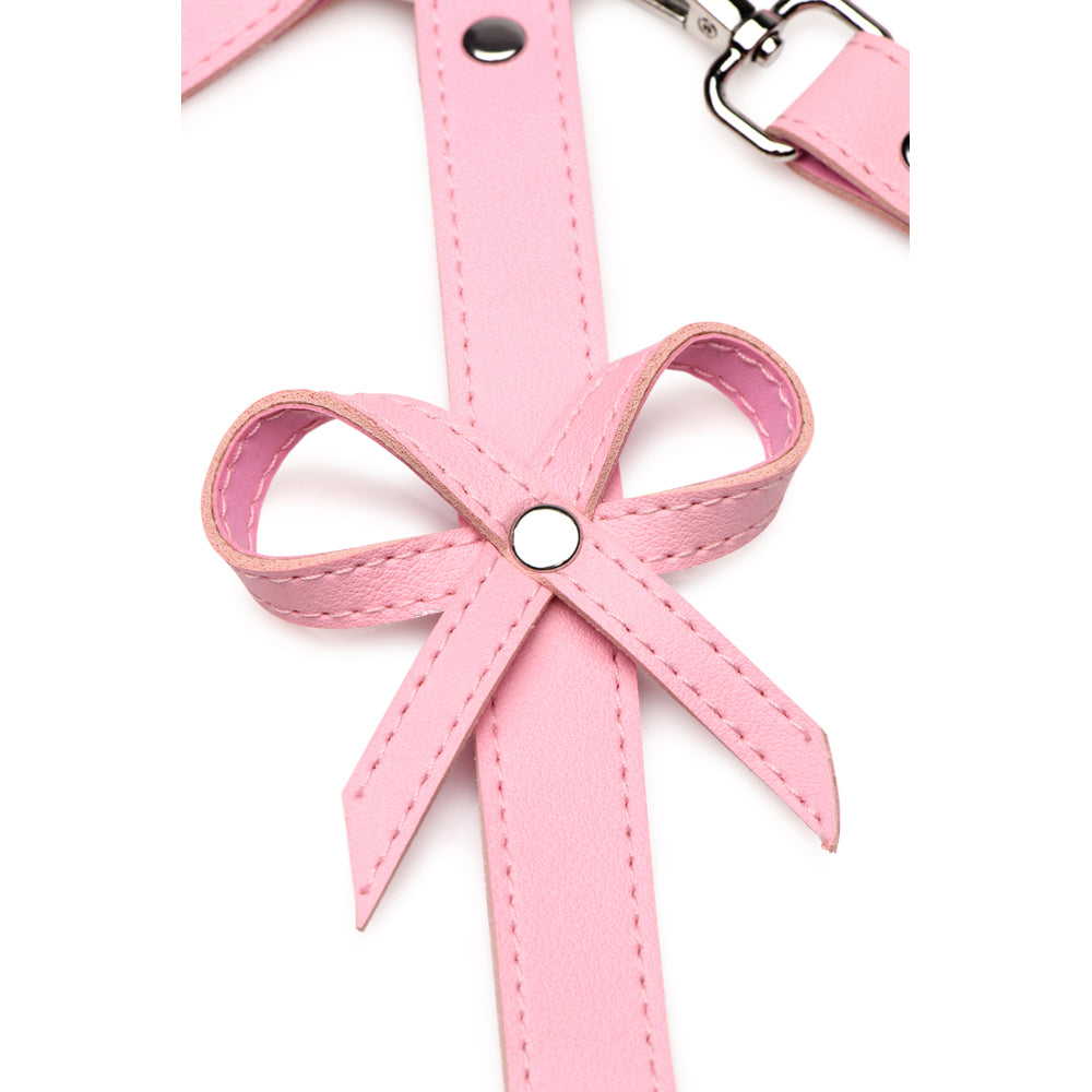 Pink vegan leather harness with a bow detail.